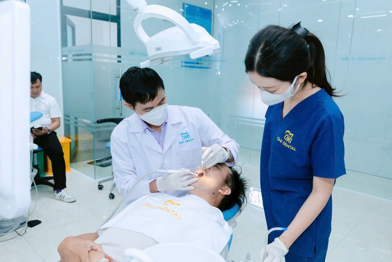 Bác sĩ và trợ thủ Nha Khoa Omi Dental Clinic mặc áo blouse và scrubs thêu logo của Minh Mỹ