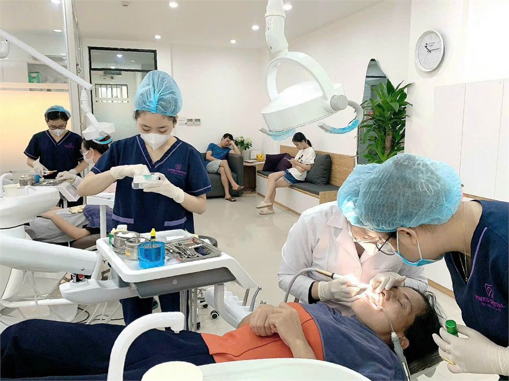 Nhân viên phòng khám nha khoa mặc bộ scrubs xanh navy thêu logo của Minh Mỹ